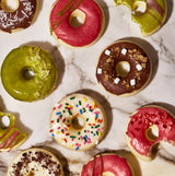 Assorted colorful donuts on a marble surface
