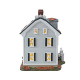 Model of a two-story house with lit windows on a white background