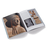 Open book showing images of stone statues on a white background