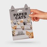 Hand holding a package of pikkii Paper Cats on a light grey background