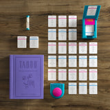 Taboo game components including cards, book, and buzzer on a wooden surface