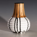 Hand turned wood vase with a white bottom half and black ink drips down the sides
