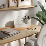 Home office desk with laptop, glasses, and water fountain on a wooden desk.