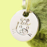 Silver cat-shaped tag on a green fluffy background