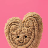 Heart-shaped plush with a smiling face on a pink background