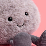 Plush toy with a smiling face on a pink background