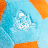 Close-up of a plush toy with a cat face design on a blue and orange background