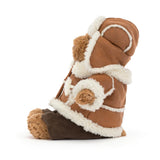 A plush teddy bear dressed in a brown suede-like winter coat with cream sherpa lining and a dark brown trousers underneath, photographed on a clean white background.