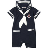 A navy blue baby romper with a white sailor collar, white necktie motif, white sleeve stripes, and a red and white anchor emblem on the chest.