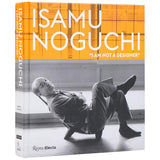Book cover of 'Isamu Noguchi: I Am Not a Designer' with a photo of Isamu Noguchi reclining in a low chair.
