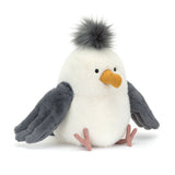 Plush toy penguin with a white body, gray wings, and a yellow beak on a white background