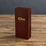 Brown 'Clue' game box on a wooden table with a dark background