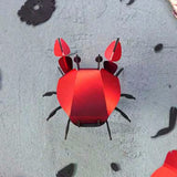 Red paper crab craft on a textured surface
