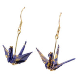 A pair of dangling origami crane earrings with gold-tone hooks and blue-and-gold paper cranes on a plain white background.