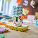 Decorative skull with colorful flowers on a polka dot box in a playful indoor setting