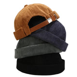 Four corduroy knit caps stacked on a white background.