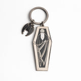 A gothic-themed metal keychain featuring a coffin-shaped pendant with an engraved vampire figure and a small bat charm, shown on a clean white background.