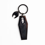 Keychain with a design of a person in a coffin on a white background