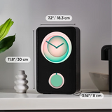 A black rectangular digital clock with a glowing circular display and a smaller round button, shown on a tabletop with dimension labels.