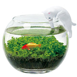 Glass fishbowl with a goldfish, green plants, and a white cat figurine on a white background