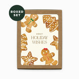 A boxed holiday notecard set with a kraft brown box and a front label reading 'SWEET HOLIDAY WISHES,' decorated with gingerbread cookies, trees, and snowflakes. A dark green circular badge in the top left says 'BOXED SET.