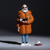 Figurine of a man in an orange coat holding a cat on a dark background