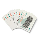 A fan of illustrated playing cards on a clean white background, showing card faces 2 through K with whimsical drawings and red and green suit symbols.