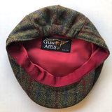 Harris Tweed flat cap in green, red and blue tartan. Red interior shown.
