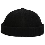 A black corduroy beanie hat with a folded cuff, shown against a white background.