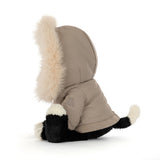 Black and white plush cat toy wearing a khaki parka with fur trim.