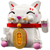 A white and gold building block toy cat figurine with a red collar, pink paws, and gold emblem, on a plain white background.