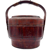 Vintage Chinese basket crafted of wood with a bamboo handle. Painted red with faded imagery.