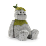 Plush toy resembling a creature with a green hat and scarf on a white background