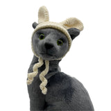 Gray plush toy with a beige knitted hat on a white background