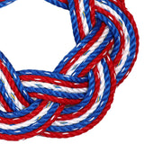 Close-up of red, white, and blue braided rope wreath on a white background