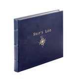 A navy blue hardcover book titled 'Ship's Log' with a gold compass rose illustration on the front cover, shown at an angle on a plain white background.