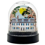 Decorative snow globe with a house illustration and floral elements on a white background