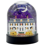 Halloween-themed snow globe with a house, pumpkins, and bats on a purple background.