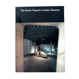 A book cover for 'The Isamu Noguchi Garden Museum' featuring a black top banner with white text and a central photograph of an indoor garden museum space framed by stone arches.