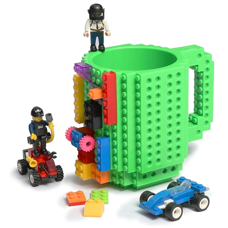 Green mug with building block design and toy figures on a white background