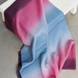 Gradient scarf transitioning from purple to pink and blue on a white surface.