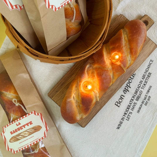 Baked bread candle with packaging on a white towel