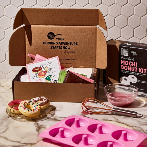 Mochi donut kit with ingredients and tools on a marble surface