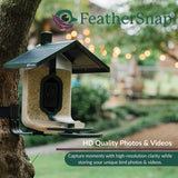 Bird feeder with solar panel and 'FeatherSnap' branding in a garden setting