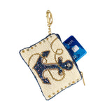Beaded pouch with anchor design and gold chain, containing a card on a white background