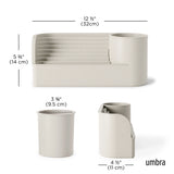 A minimalist water fountain in a light warm gray/beige tone, shown with overlaid dimension lines and measurements for width, height, and depth on a white background. The brand name 'umbra' appears in the lower right.