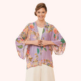 Woman wearing a floral kimono-style top on a white background