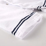 Close-up of a white romper with navy blue stripes on a light gray background