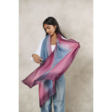 Woman wearing a colorful scarf with a neutral background