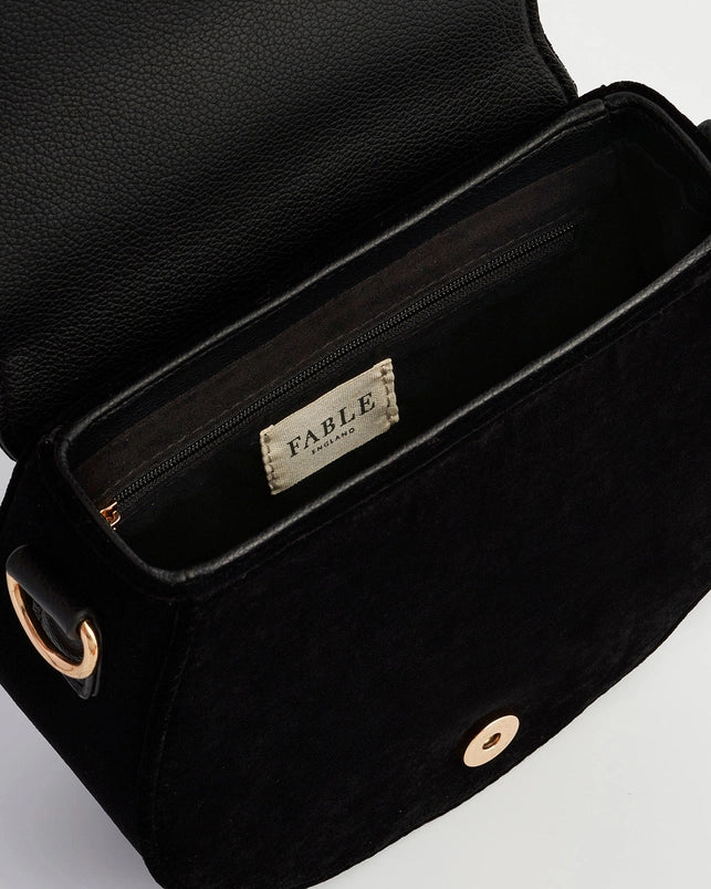 Black leather bag with 'Fable' brand label on a light gray background